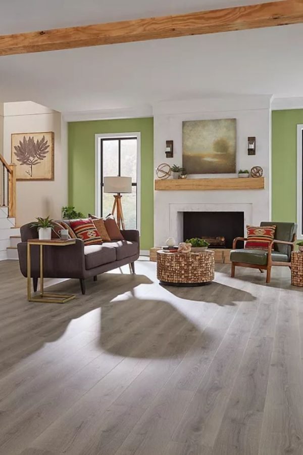 A stylish living room with green walls and wooden flooring, representing flooring services in San Jose, CA.